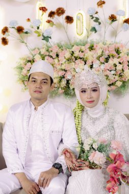 Kültürel kıyafetler giyen geleneksel evli çift şapkalı adam ve dekoratif taçlı kadın aşkı, birliği ve mirası sembolize ediyor. Geleneksel düğünleri resmetmek için mükemmel,