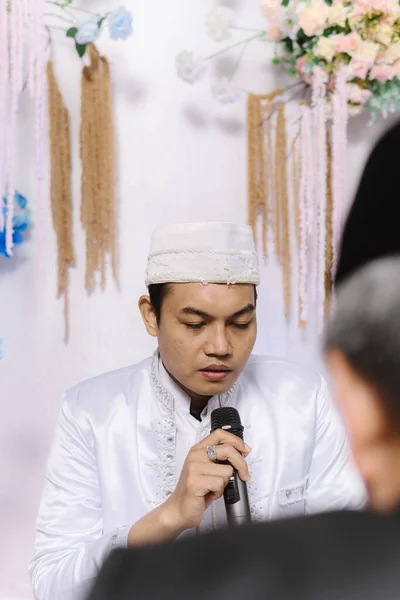 Geleneksel beyaz giysili ve siyah şapkalı Asyalı bir adam basitliği, inancı ve kültürel mirası simgeliyor. İslami gelenekleri, dini etkinlikleri, düğünleri ve kültürleri resmetmek için mükemmel. 