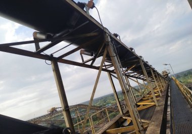 Endüstriyel madenlerde yukarı doğru kömür taşıyan yerleştirilmiş şerit taşıyıcı, enerji üretimini, hammadde taşımacılığını ve ağır sanayiyi simgeliyor. Madencilik işlemleri için ideal, toptan 