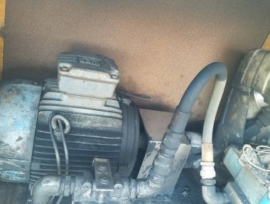 Hidrolik makine endüstriyel bir ortamda şerit taşıyıcı kullanıyor, ağır ekipman, güç ve malzeme kullanımını sembolize ediyor. Madencilik, imalat ve mühendislik için ideal,