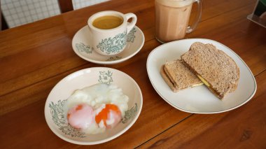 Çeşitli Kopitiam menüleri, kahve, süt çayı, kaya tostu ve onsen yumurtası.