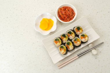 Kore usulü Gimbap, danmuji ve kimchle servis edilir.