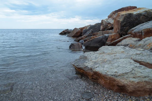 Sea stone breakwater against the sea and evening sky — Stock Photo, Image