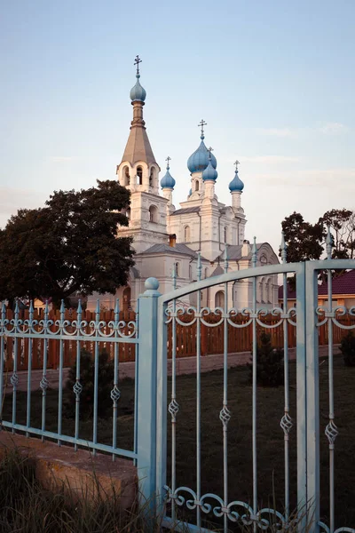 Igreja de Pedro e Paulo na aldeia de Vetvenik com portões de ferro forjado ao pôr do sol . — Fotografia de Stock