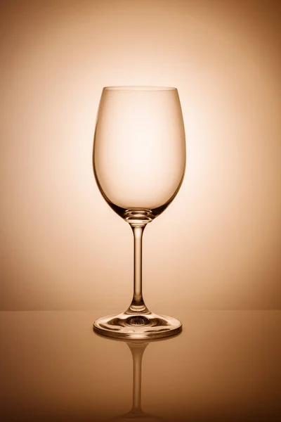 Copo de vinho vazio isolado no fundo claro tonificado laranja . — Fotografia de Stock