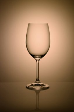 Açık renkli tonda turuncu izole boş şarap kadehi.