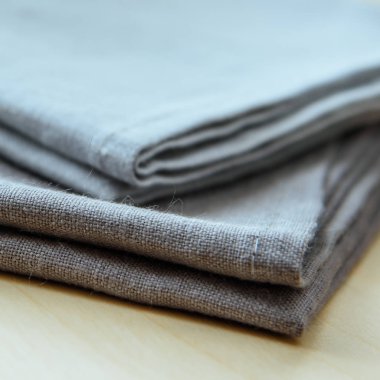 Ahşap arka plan üzerinde gri havlu yığını izole kare çekim yakın çekim.