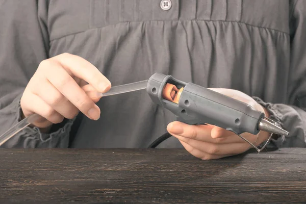 Concept photo childrens hands fill and adjust the glue gun. — Stock Photo, Image