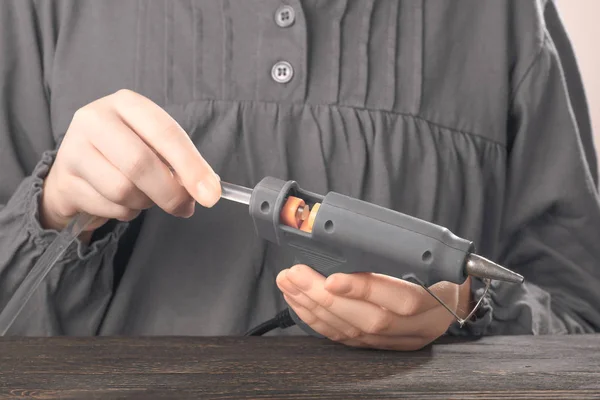 Concept photo childrens hands fill and adjust the glue gun. — Stock Photo, Image