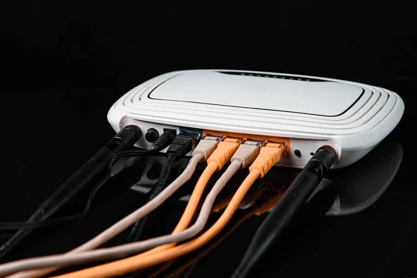 Router con cables, cable para Internet con reflexión, aislado sobre fondo negro . — Foto de Stock