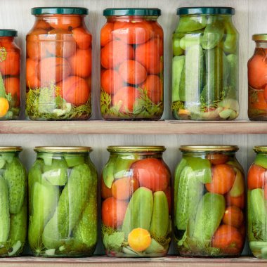 Satırlar halinde ahşap raflar ayakta ev sebze konserveleri ile cam kavanoz yakın çekim.