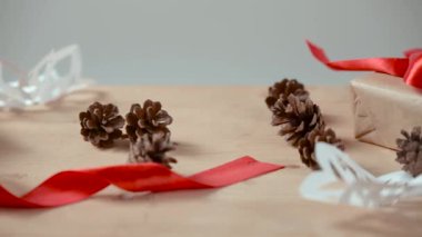 Kraft kağıt, kar taneleri üzerinde ahşap masa lambası beyaz kağıt, çam kozalakları, kırmızı kurdele kesme Noel ve yeni yıl konseri hediyeler Paketli.