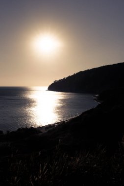 Deniz on Sunset. Gün batımında dağ silueti.