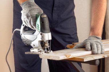 Üniformalı kırpma adamla bir Yapboz onun elinde tahta kesmek hazırlanıyor.