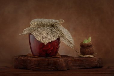 Pickled red betroot in jar on wooden background. clipart