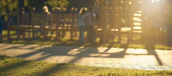Sfocatura Parco giochi con i bambini della luce solare brillante nel parco sfondo astratto . — Foto Stock
