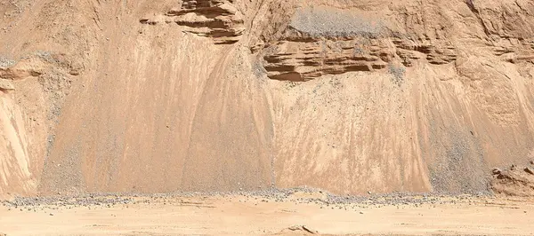 Die Straße bei einem Sandbruch vor dem Hintergrund sandiger Hügel. Industriesandsteinbruch. — Stockfoto