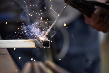 Kaynak yakın çekim ile iki parçanın bağlantısı. Kıvılcımlarla taşlama bir fabrikada bulanıklık metal wroker
