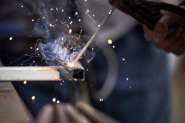 Kaynak yakın çekim ile iki parçanın bağlantısı. Kıvılcımlarla taşlama bir fabrikada bulanıklık metal wroker