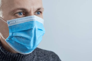 Gri arka planda izole edilmiş koruyucu maske takan yakın plan fotoğrafçı..