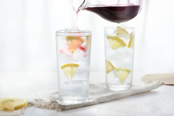 Två glas iskall lemonad på linne servett på vit bakgrund i oskärpa. — Stockfoto