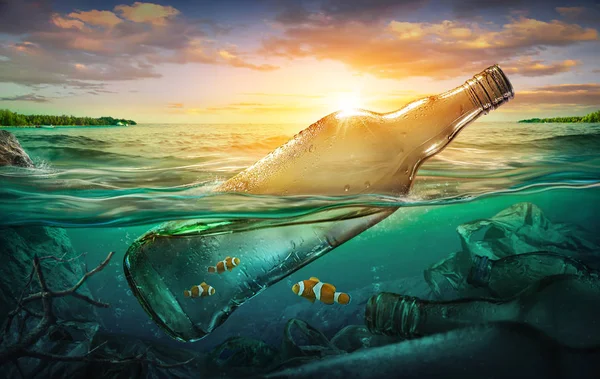 Small fishes in a bottle among ocean pollution. Environment concept