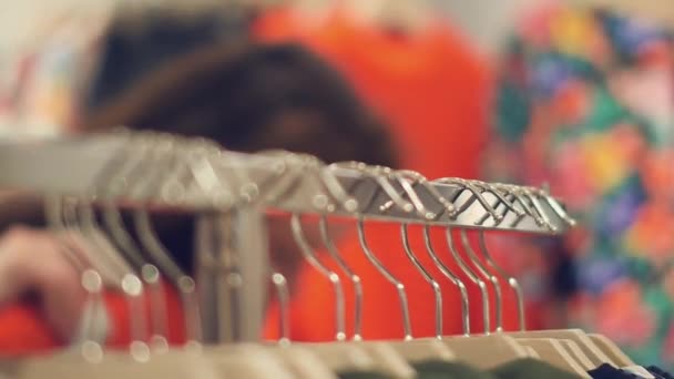 Una mujer joven en la tienda elegir ropa de invierno caliente — Vídeo de stock