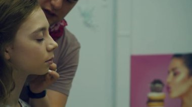 Erkek makyöz makyaj genç bir kadın koyar. Asıl makyaj hakkında bir grup kız söyler. Makyaj sanatçıları için ana sınıfı.