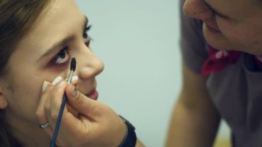 Erkek makyöz makyaj genç bir kadın koyar. Asıl makyaj hakkında bir grup kız söyler. Makyaj sanatçıları için ana sınıfı.