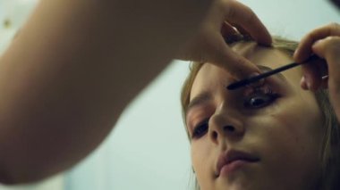 Erkek makyöz makyaj genç bir kadın koyar. Asıl makyaj hakkında bir grup kız söyler. Makyaj sanatçıları için ana sınıfı.