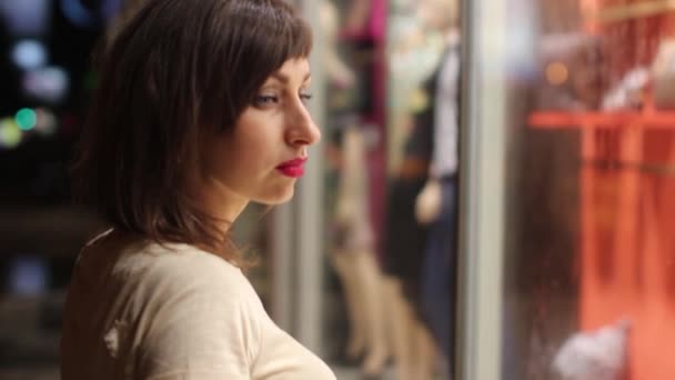 Młoda kobieta patrząc w sklepie windows — Wideo stockowe