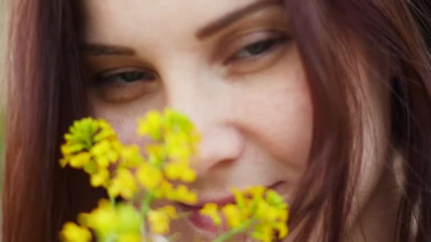 Portret van een lachende vrouw buitenshuis. Gele bloemen in de handen van vrouwen — Stockvideo