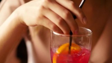 Bir akıllı telefon elinde güzel bir kadınla bir kokteyl barda içecekler.