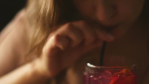Krásná žena s chytrým telefonem v ruce pije koktejl v baru — Stock video