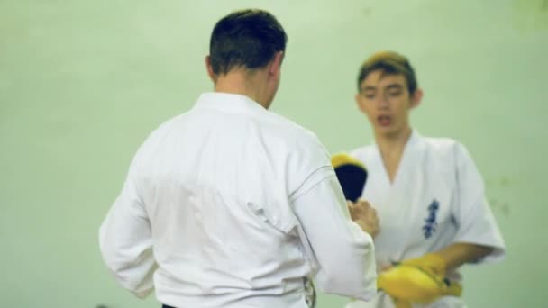 Rusia, Novosibirsk, 15 de agosto de 2018 Un grupo de personas que practican golpes de karate en el interior. Entrenamiento de resistencia en karate — Vídeos de Stock