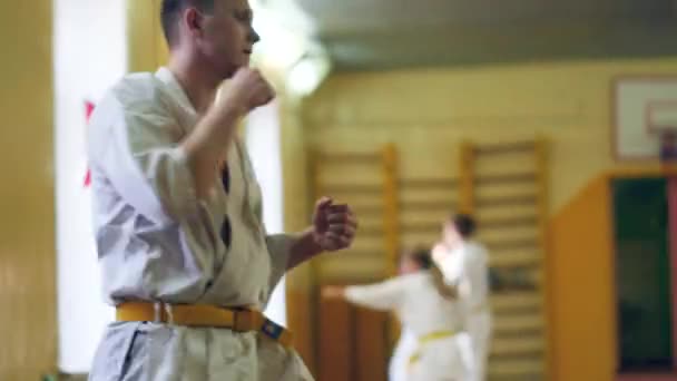Rosja, Nowosybirsk, 15 sierpnia 2018 A grupę osób praktykujących karate obrysy wewnątrz. Trening wytrzymałościowy w karate — Wideo stockowe