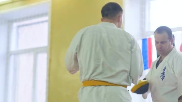 Rusia, Novosibirsk, 15 Agustus 2018 Sekelompok orang berlatih stroke karate di dalam ruangan. Pelatihan ketahanan dalam karate — Stok Video