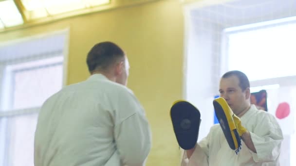 Ryssland, Novosibirsk, 15 augusti, 2018 A grupp av människor som utövar karate stroke inomhus. Uthållighetsträning i karate — Stockvideo