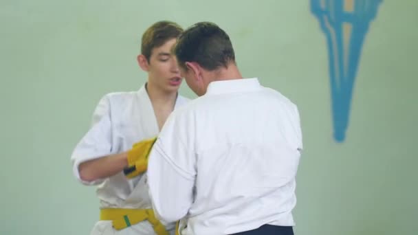 Rusko, Novosibirsk, 15 srpna 2018 A skupina lidí cvičí karate tahy uvnitř. Vytrvalostní trénink v karate — Stock video