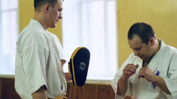Rusia, Novosibirsk, 15 de agosto de 2018 Un grupo de personas que practican golpes de karate en el interior. Entrenamiento de resistencia en karate — Vídeos de Stock