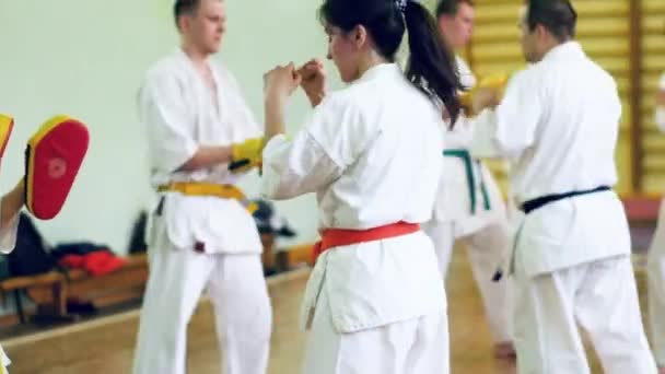 Ryssland, Novosibirsk, 15 augusti, 2018 A grupp av människor som utövar karate stroke inomhus. Uthållighetsträning i karate — Stockvideo