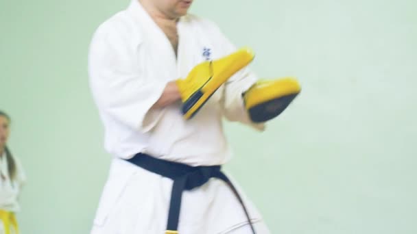 Rusia, Novosibirsk, 15 de agosto de 2018 Un grupo de personas que practican golpes de karate en el interior. Entrenamiento de resistencia en karate — Vídeo de stock