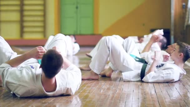 Rusia, Novosibirsk, 15 Agustus 2018 Sekelompok orang berlatih stroke karate di dalam ruangan. Pelatihan ketahanan dalam karate — Stok Video