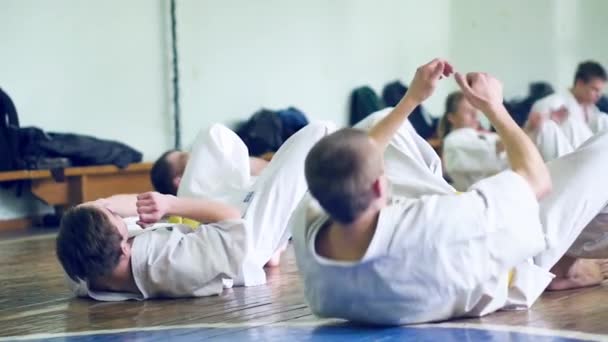 Russland, nowosibirsk, august 15, 2018 eine gruppe von menschen, die karate-schläge drinnen üben. Ausdauertraining im Karate — Stockvideo