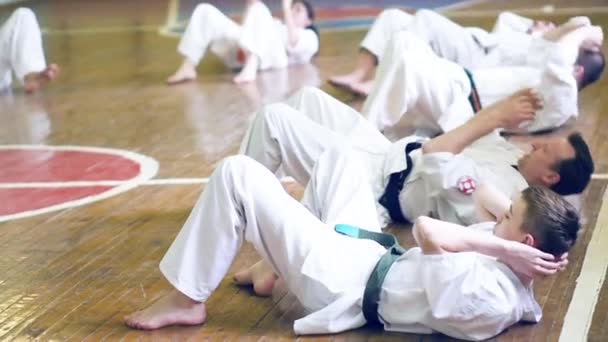 Rusko, Novosibirsk, 15 srpna 2018 A skupina lidí cvičí karate tahy uvnitř. Vytrvalostní trénink v karate — Stock video
