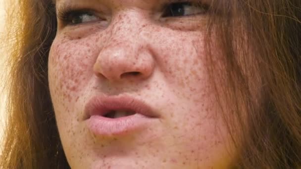 Retrato de una joven pelirroja con pecas, expresando sorpresa, decepción, indignación. indignación. Primer plano. El concepto de emociones — Vídeo de stock