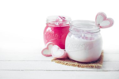 Ahşap arka plan üzerinde kalp şekli marshmallow ile pembe muzlu süt