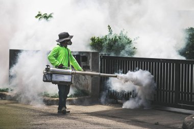 Sivrisinektehlikeli kontrol etmek için fogger makinesi kullanan adam 