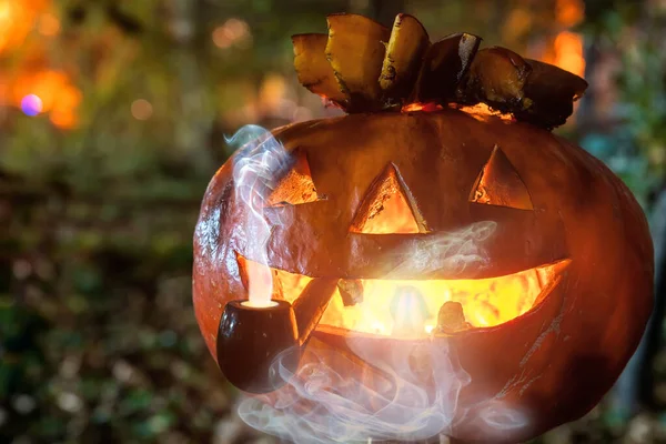 Sonriente calabaza símbolo de la fiesta de halloween sosteniendo una pipa para fumar tabaco en la boca. Jack fuma una pipa. — Foto de Stock