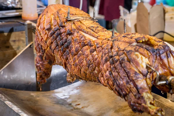 Bir şişte kızartılmış domuz üzerinde bir piyasa ahır görmek